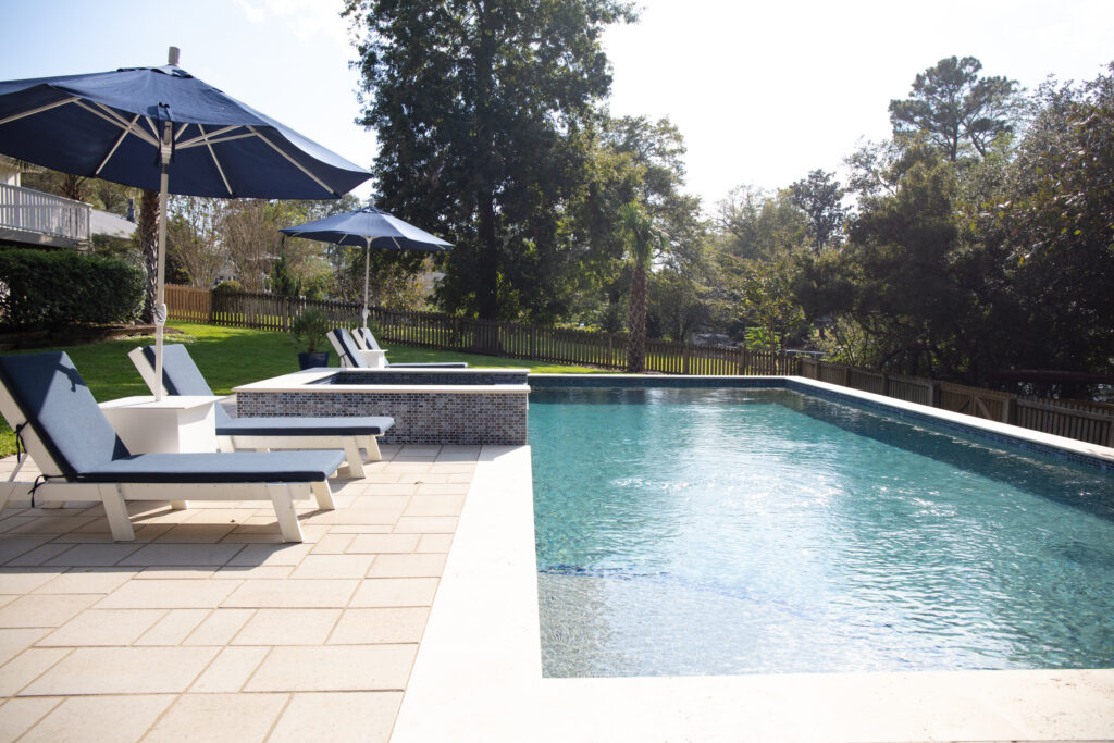 Poolside loungers and umbrellas by water