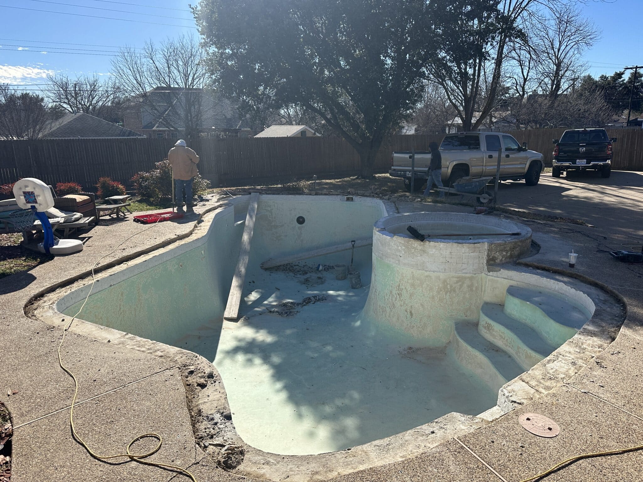 Empty pool under renovation in backyard